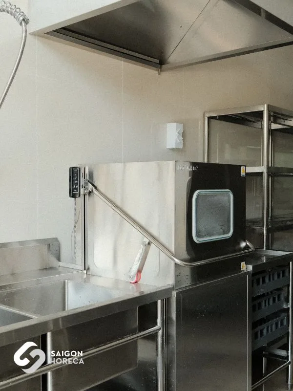 Máy rửa chén công nghiệp inox bên cạnh bồn rửa và kệ chứa khay tại bếp Sheh Fung