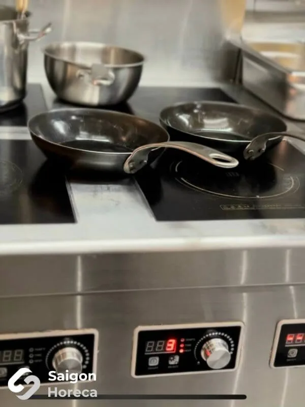 Crisply fabricated stainless steel surfaces paired with high-end culinary equipment at Little Bear