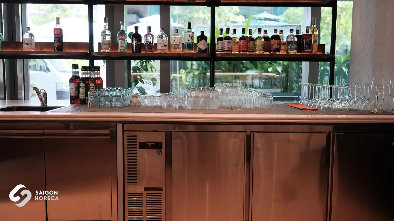 Quầy bar lounge Mâm Mâm với tủ mát inox âm quầy, ly thủy tinh và kệ rượu trưng bày