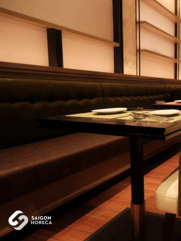 Dark wood dining tables paired with cozy leather-upholstered chairs in a European tea room style.