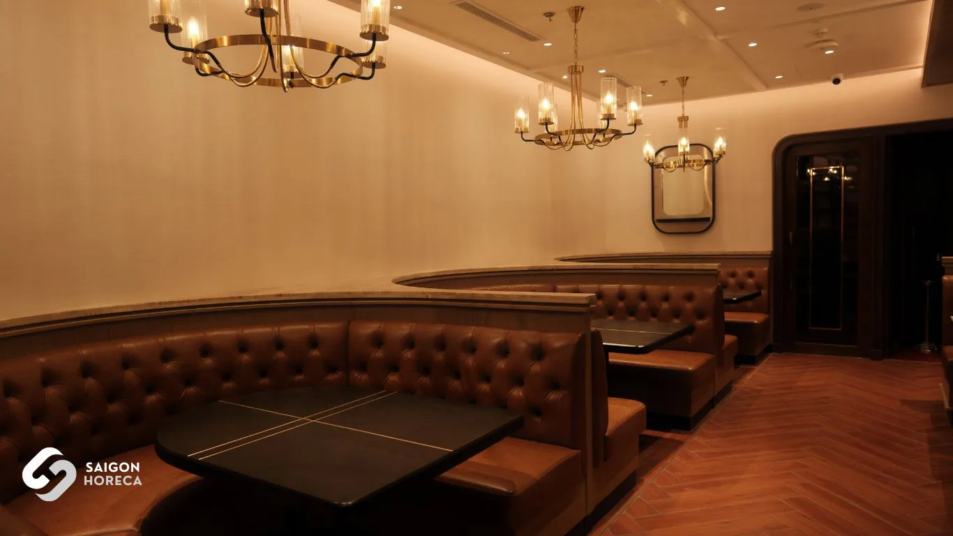 Cozy brown leather sofa row under classic chandeliers at The Royal