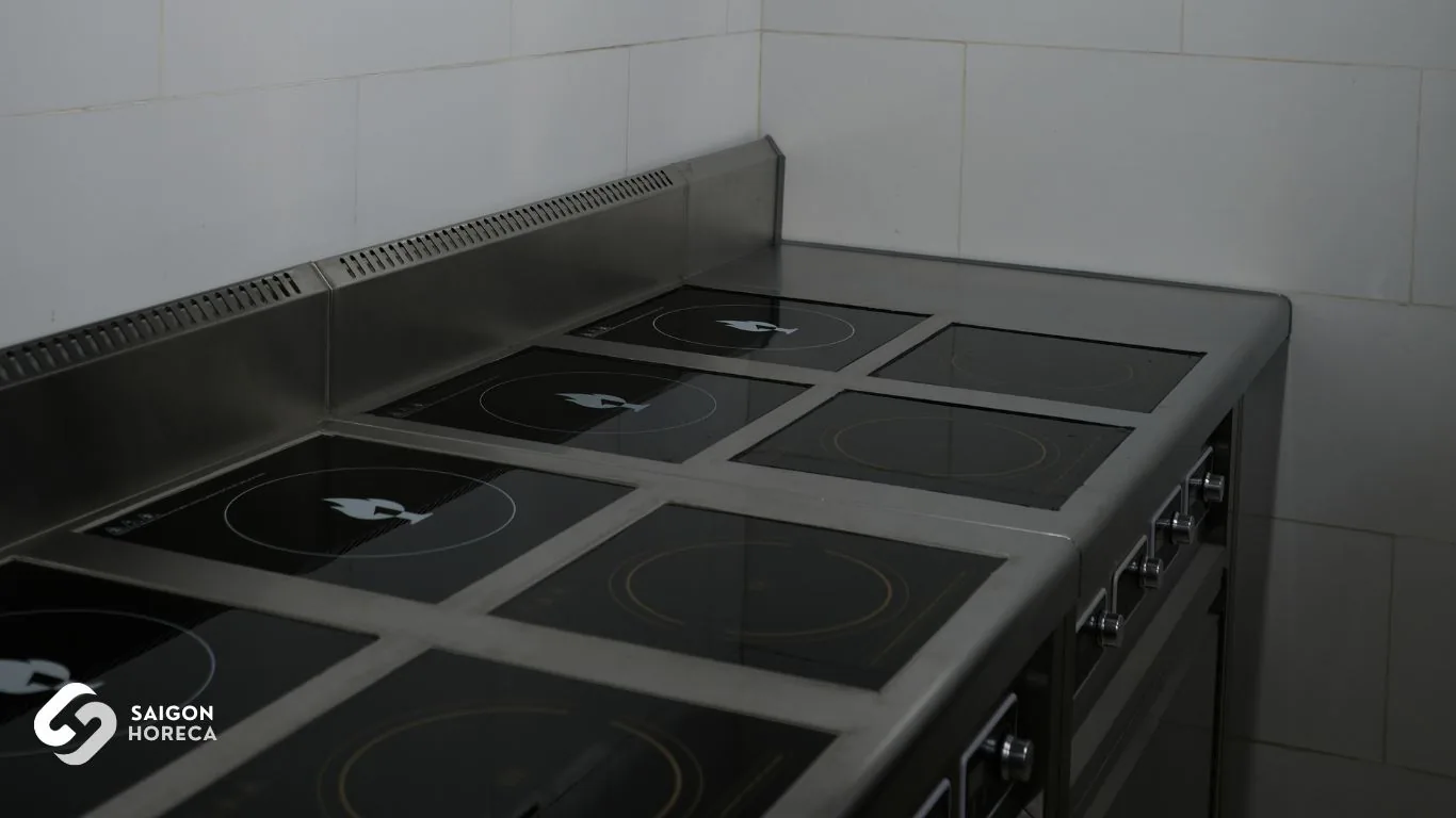 Bếp từ công nghiệp mặt kính đen khung inox nhiều vùng nấu — thiết bị nấu cốt lõi bếp Nam An do Saigon Horeca thi công