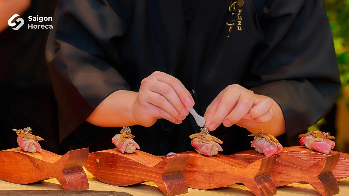 Nghệ thuật bày biện Nigiri trên giá đỡ cá gỗ thủ công với nhũ vàng và trứng cá tầm hoàng gia